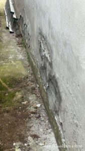 humidite ascensionnelle mur ancien : decollement d'enduit ciment et effritement en pied de mur en maconnerie traditionnelle