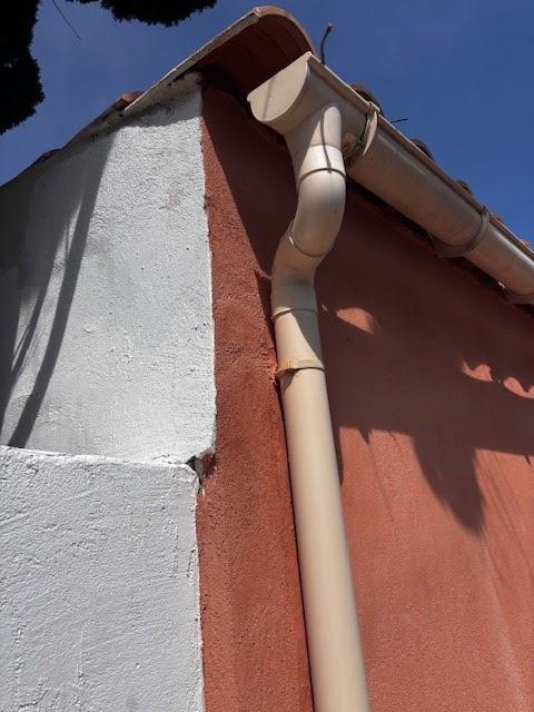 Coulures blanchâtres sur façade sous une descente pluviale, indice d'infiltration pour le constat amiable dégât des eaux.