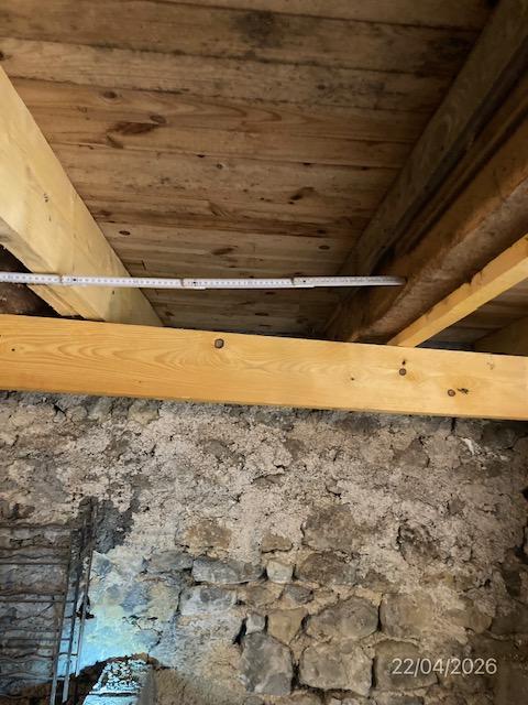 Affaissement de solivage bois sur mur en pierre relevé au mètre ruban pendant une expertise contradictoire de sinistre.