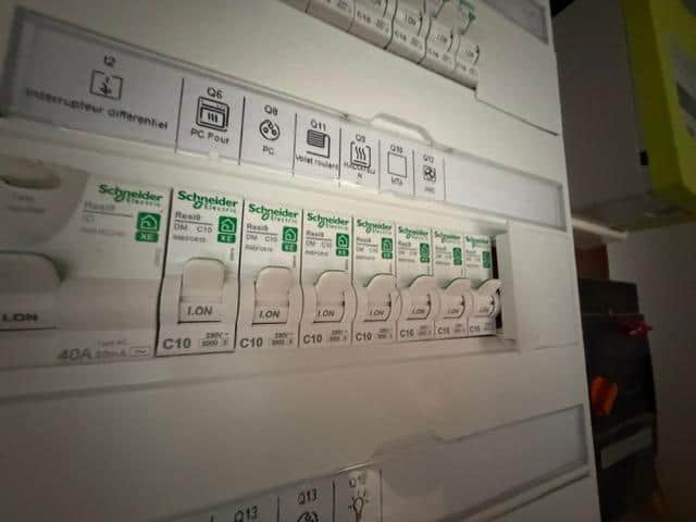 Disjoncteurs alignés sur un tableau électrique intérieur, point de contrôle lors d'une expertise de dommages électriques.