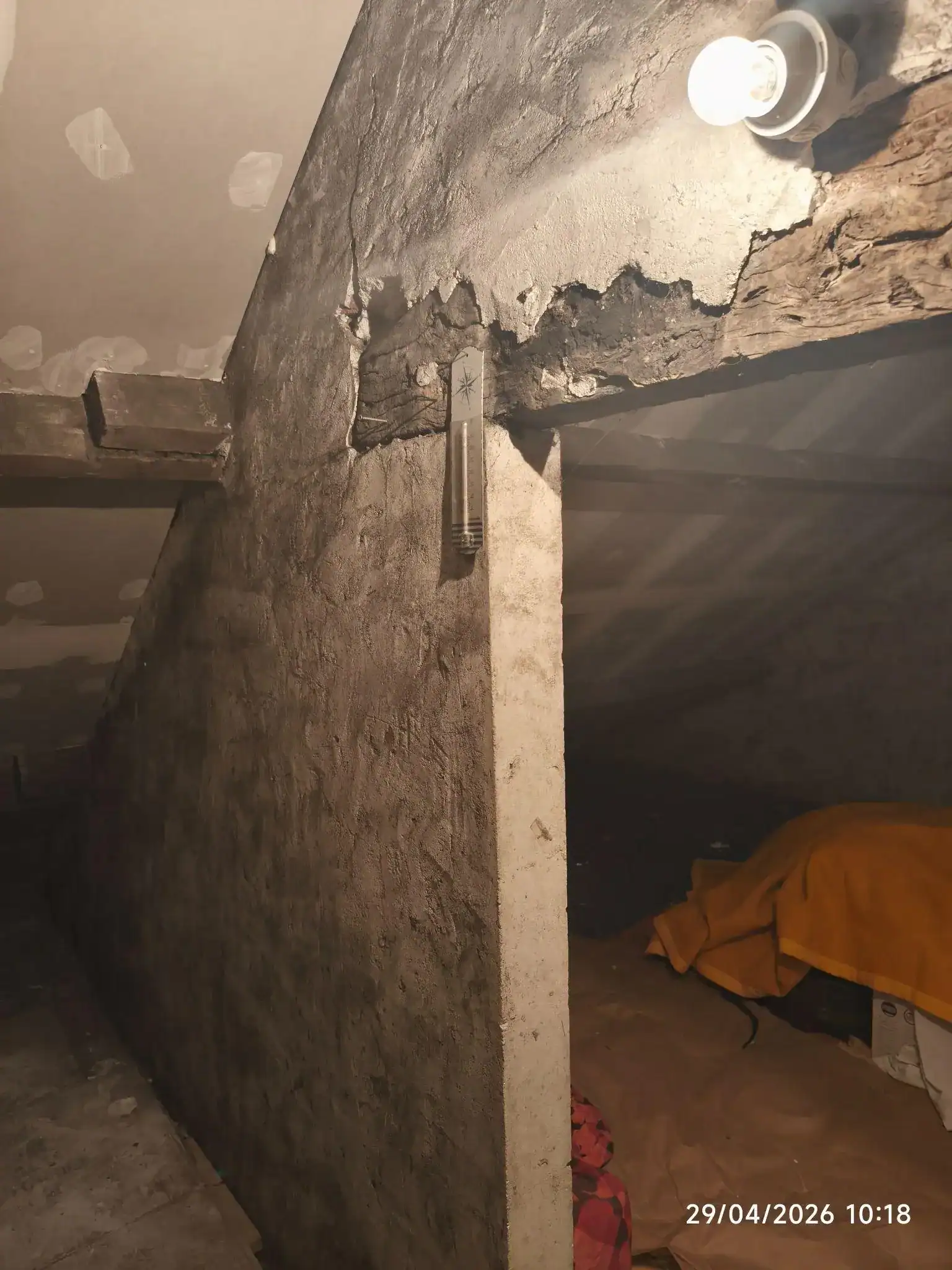 Linteau bois ancien en grenier au contact d'une maçonnerie fissurée, point de contrôle typique d'une recherche de mérule bois.