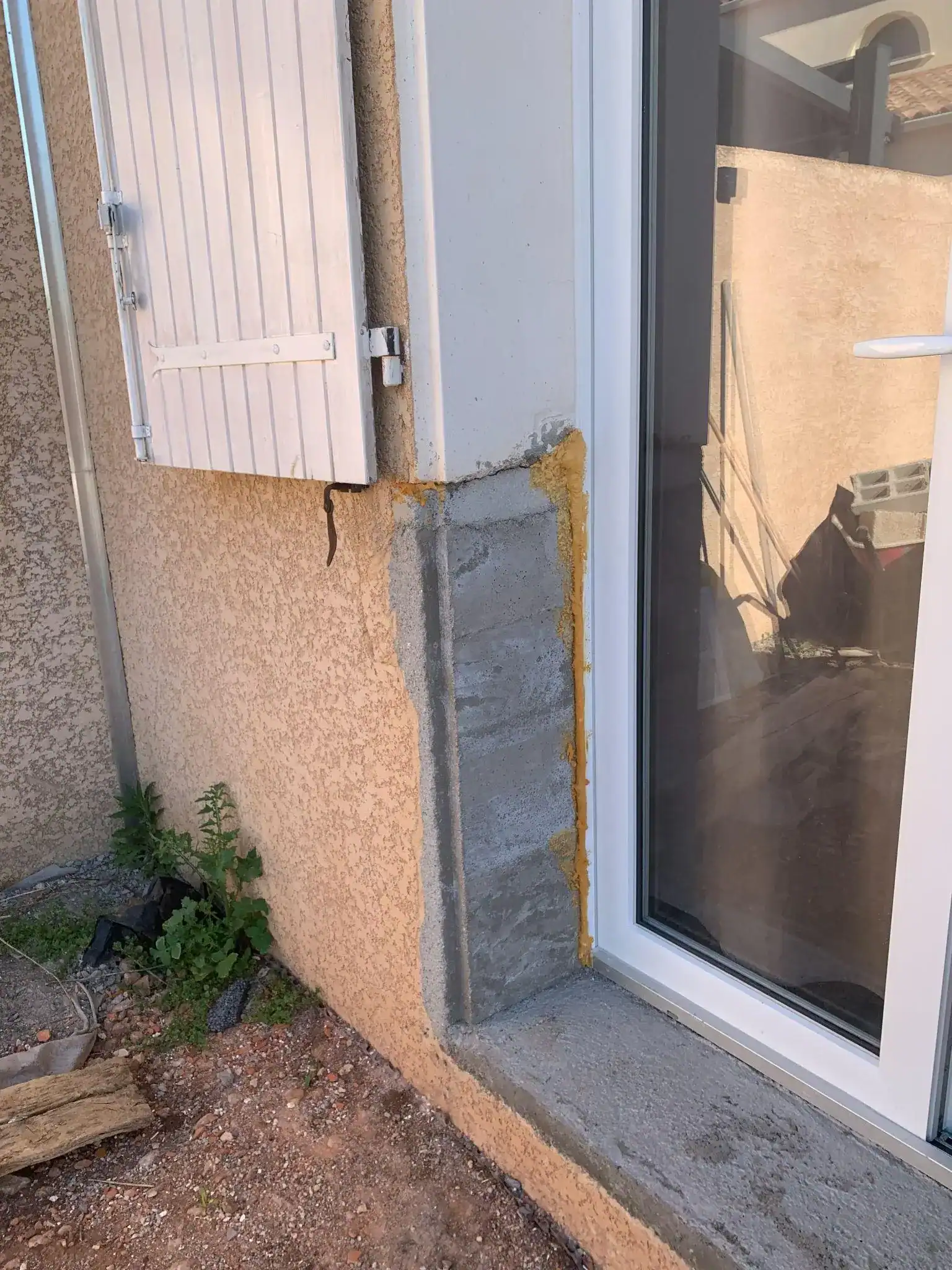 Tableau de porte-fenêtre sans enduit ni finition après travaux, relevé lors d'un constat de sinistre.