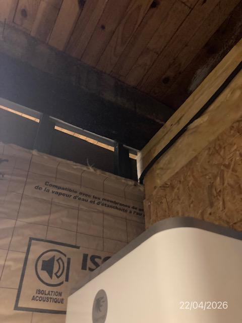 Plaques de plâtre inachevées sous charpente bois : des travaux facturés non réalisés en finition de garage.